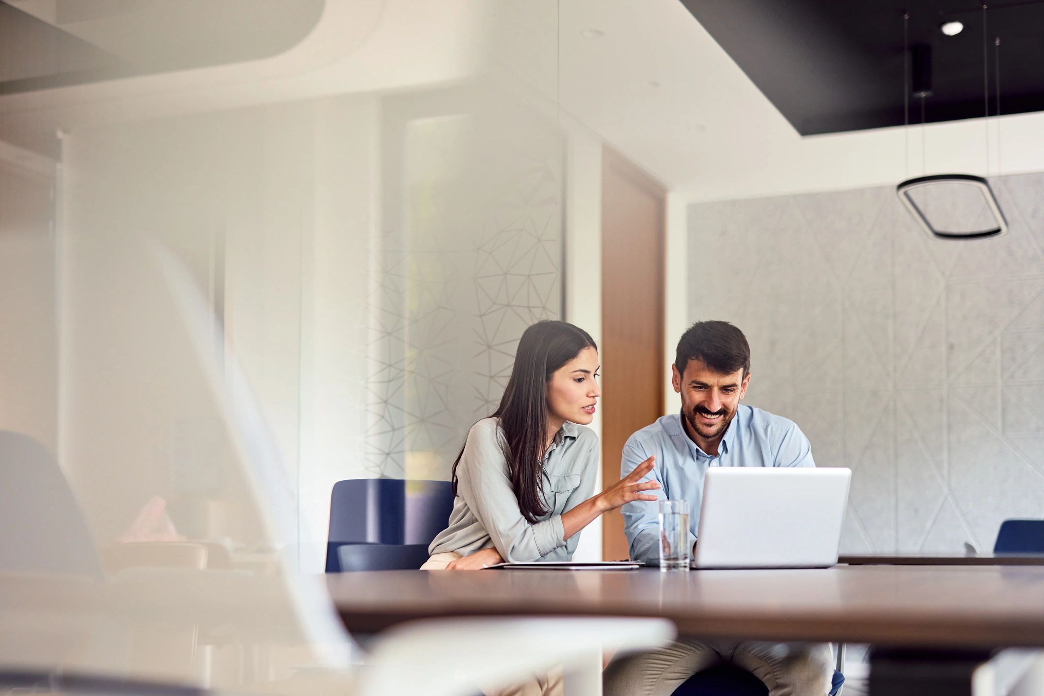 Two professionals collaborating in a modern office
